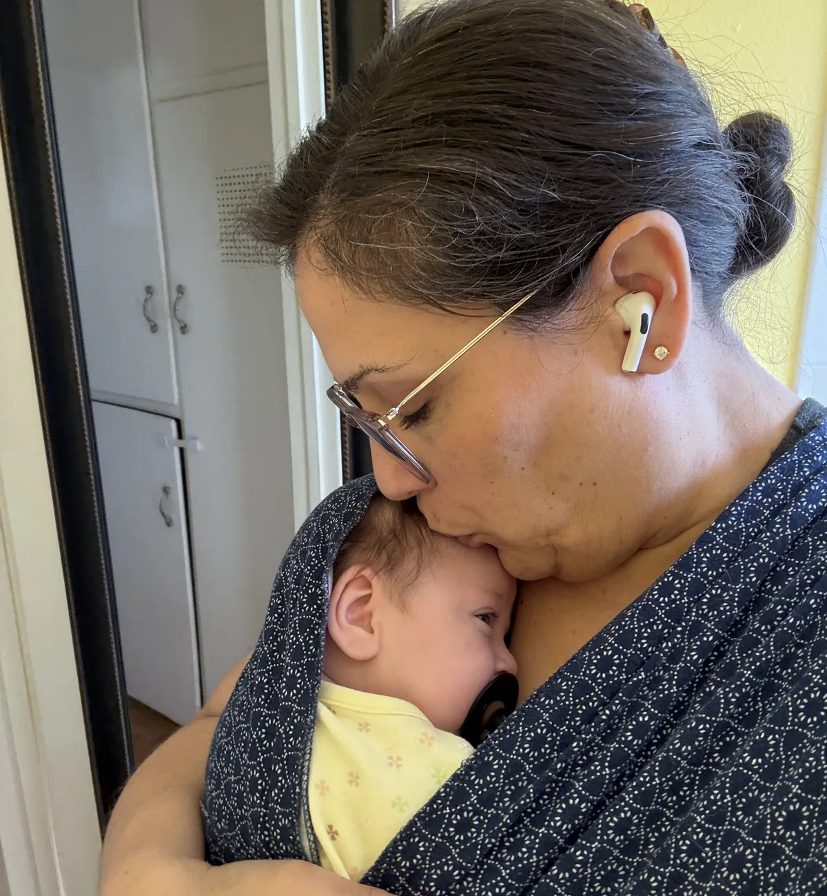 Ellie Noriega holding her daughter in a baby carrier
